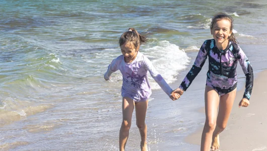 cheerful-little-girls-sisters-play-on-the-seashore-2023-11-27-05-24-37-utc