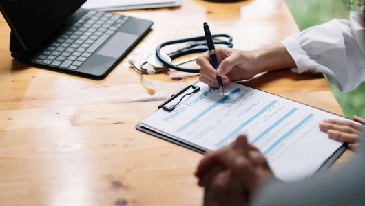 female-health-insurance-broker-presenting-his-insu-2022-08-18-23-12-56-utc-scaled