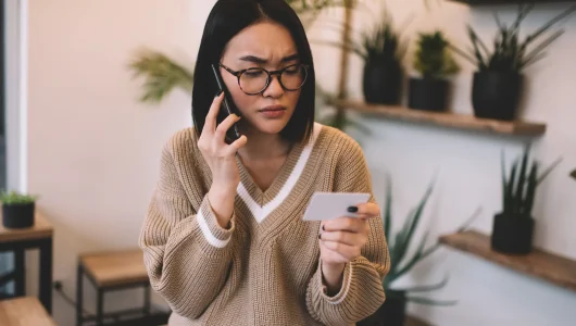 girl-with-business-card-talk-on-smartphone-in-cafe-2023-11-27-05-35-51-utc