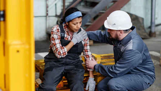 mature-foreman-in-workwear-giving-first-aid-to-fem-2023-11-27-05-07-06-utc